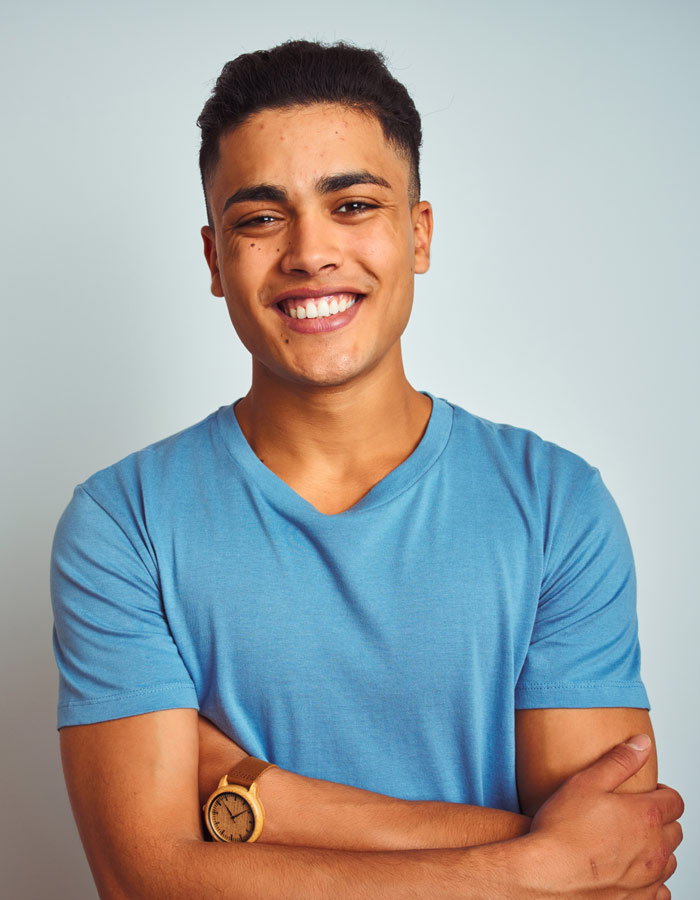 young man smiling with his arms crossed